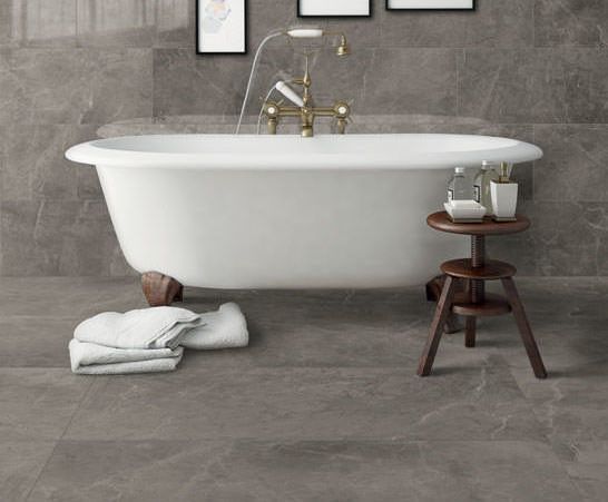 Shows a catalog scene featuring a grey marble tiled wall and floor contrasted by an elegant white classic style bathub