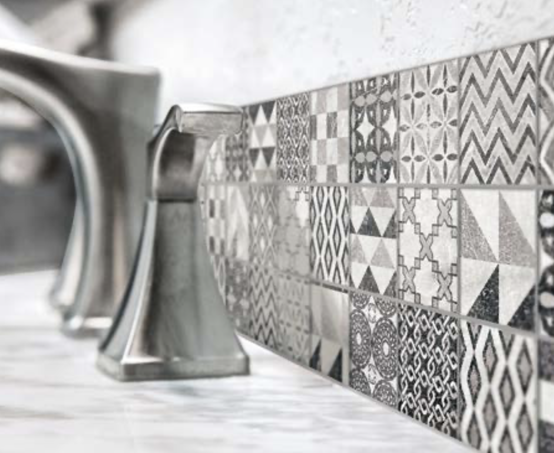 Shows a catalog scene featuring a decorative black and white backsplash on small tiles behind a steel faucet sink