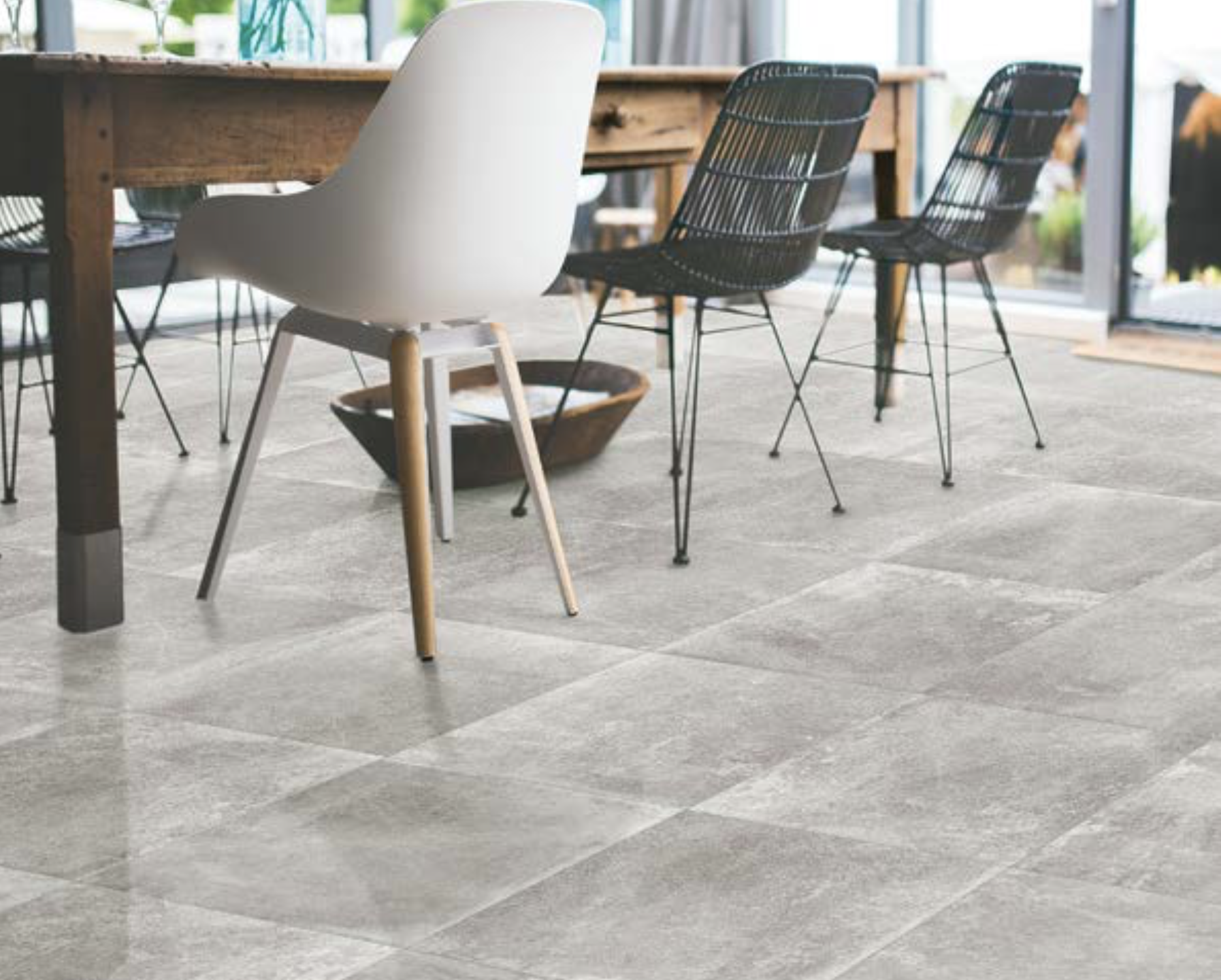 Shows a catalog scene featuring light grey natural stone looking tile in a casual dining room